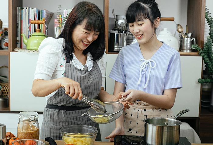 A mother and daughter cooking.